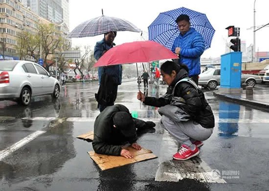 老人雨中摔伤众人撑伞救护:搭把手这都不叫事
