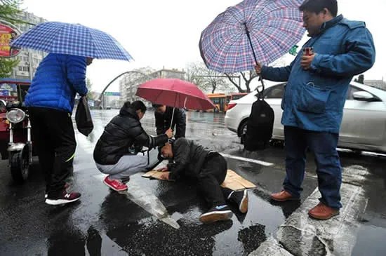 老人雨中摔伤众人撑伞救护:搭把手这都不叫事